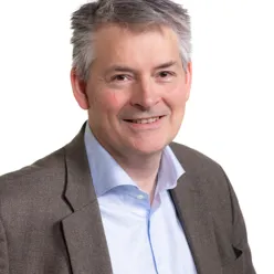 En mann i dress som smiler