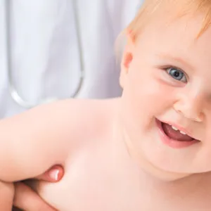 En baby med en hånd i ansiktet